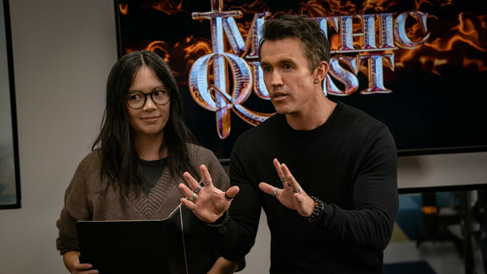 Poppy Li et Ian Grimm devant le logo de Mythic Quest